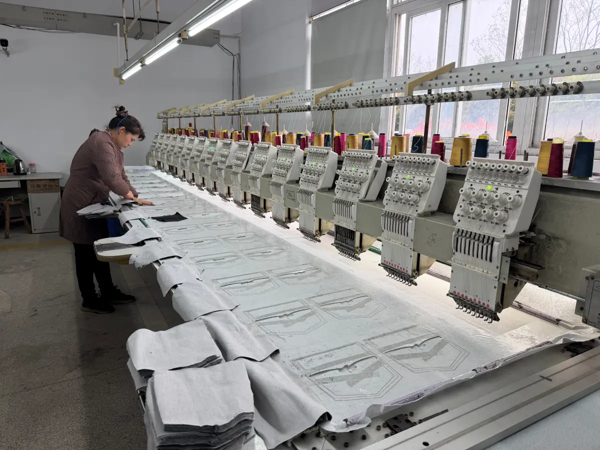 Operator running multi-head embroidery machines on denim panels